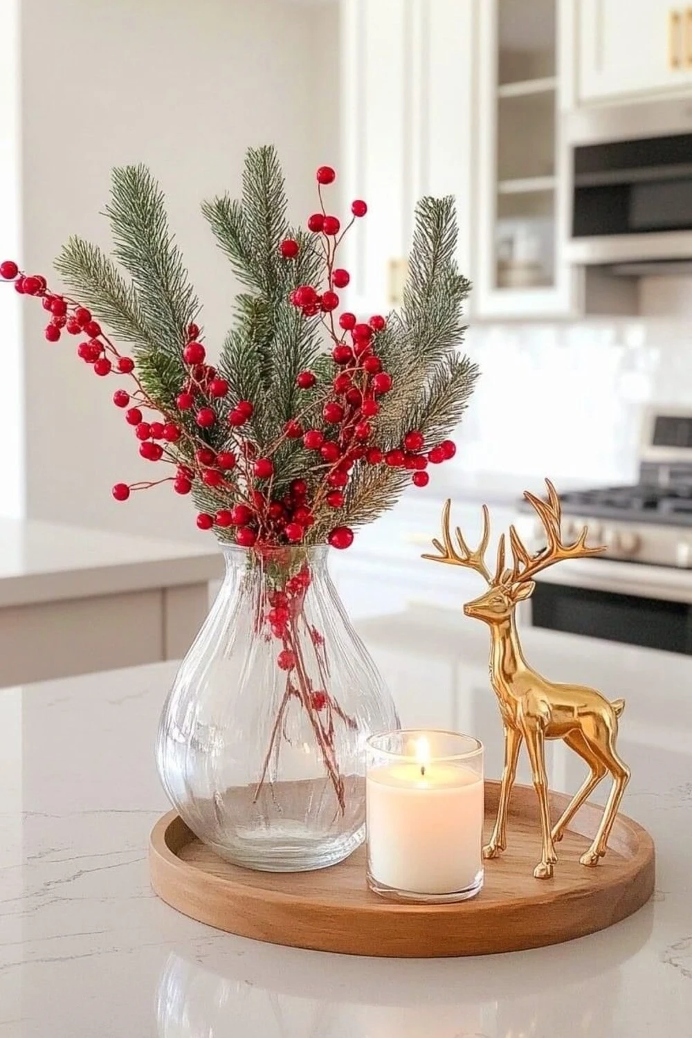 a wood tray with a reindeer figure, a candle, and a bunch of mistletoe on kitchen island