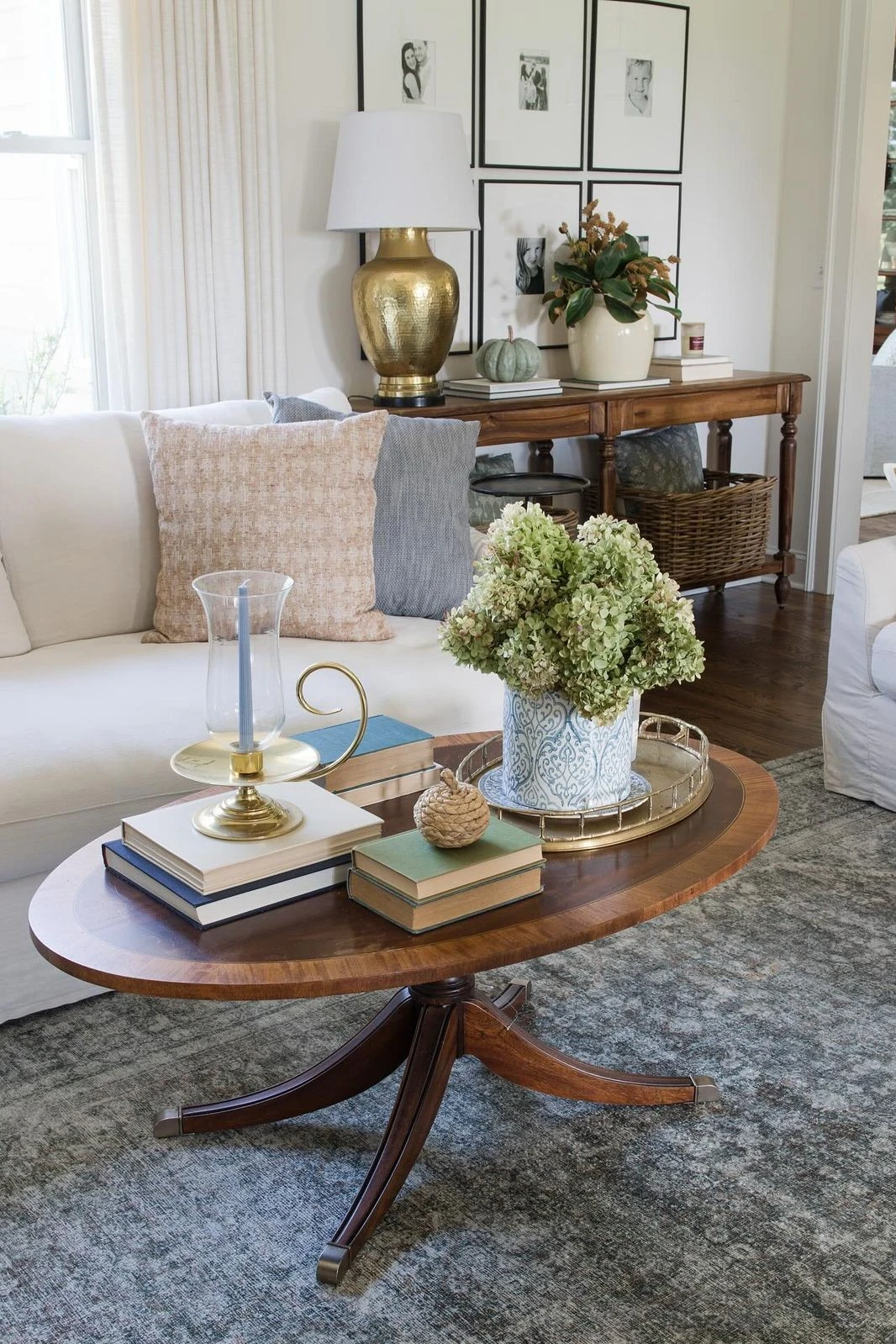 an oval coffee table with books, plant and tray