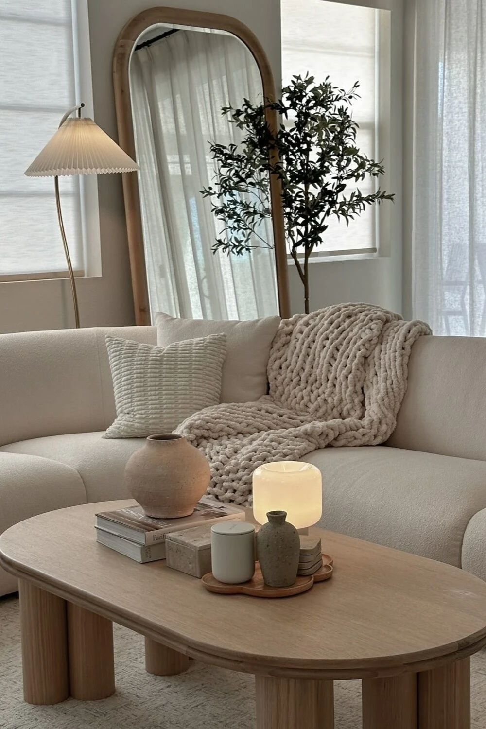a wooden oval coffee table with light color vase and led light