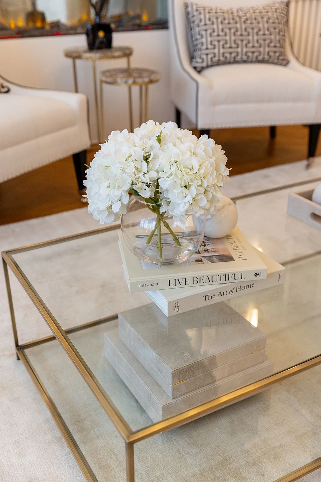 a rectangle glass coffee table with books and flower on them