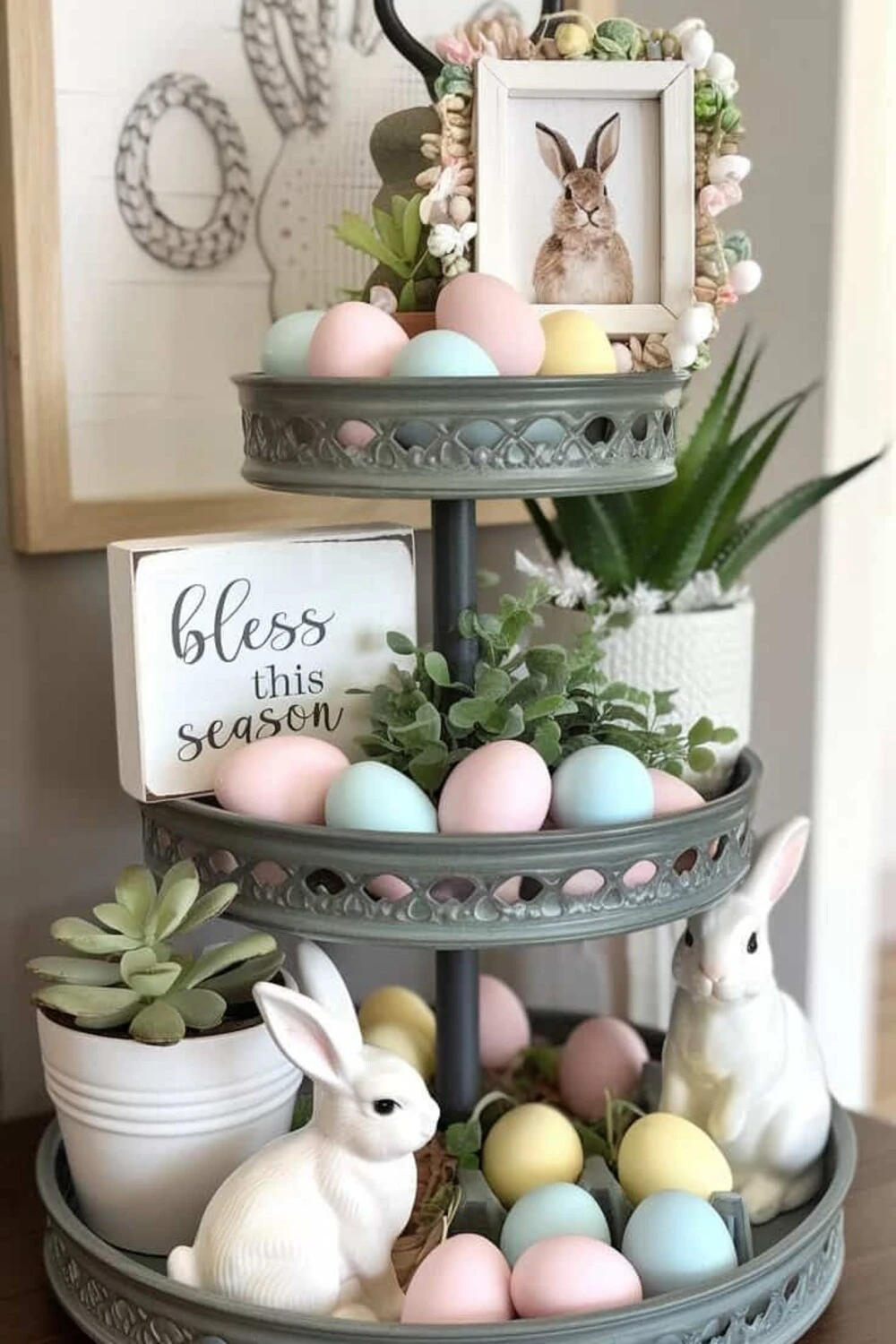 a metal tiered tray with eggs and bunny figures for spring
