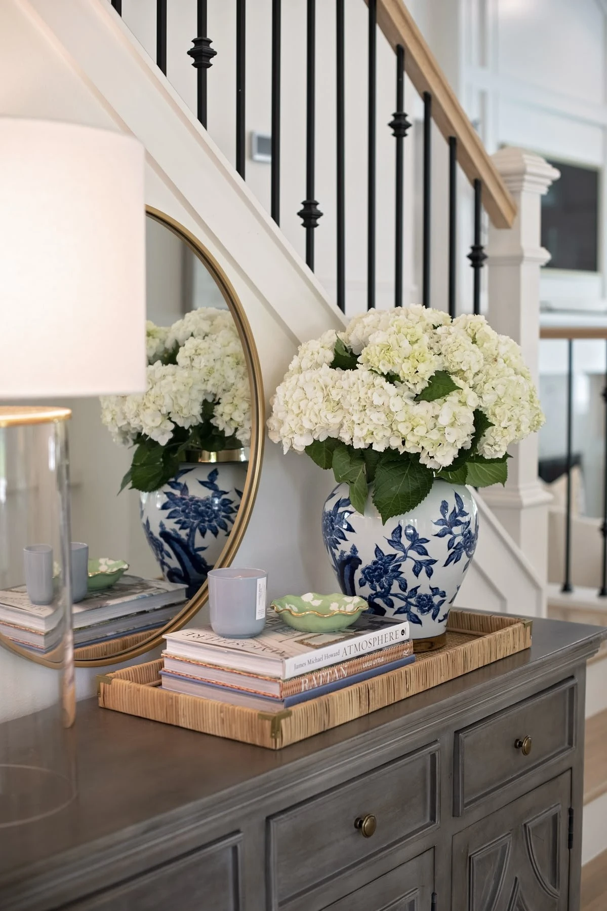 an entryway tray with books and flowers