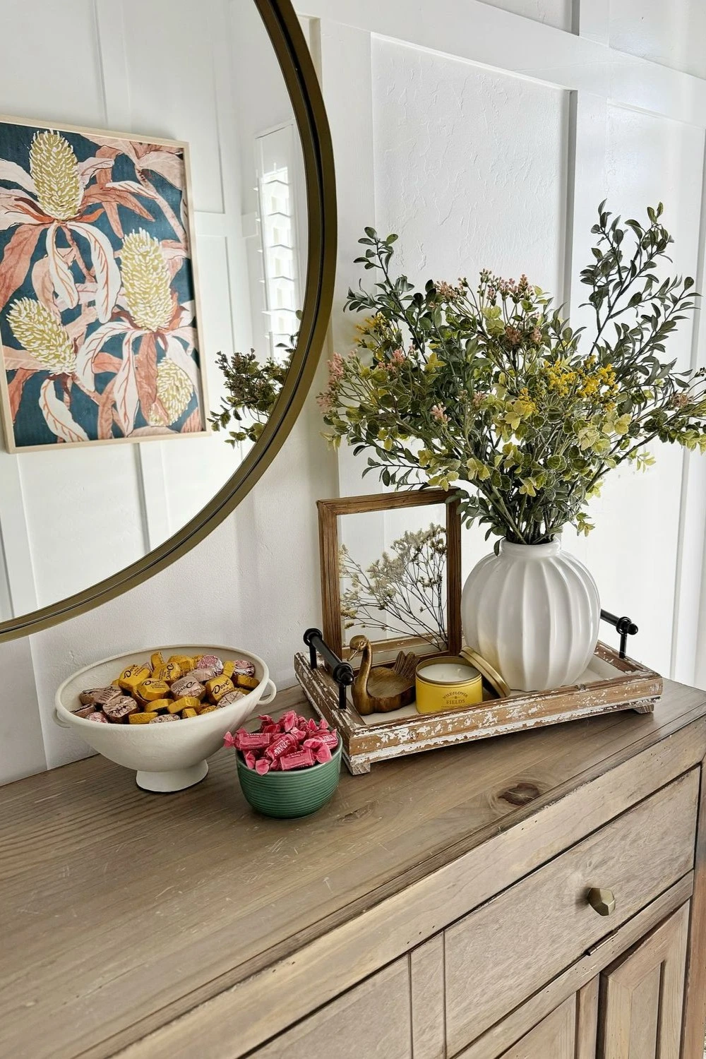 an entryway tray with ceramic vase and scent