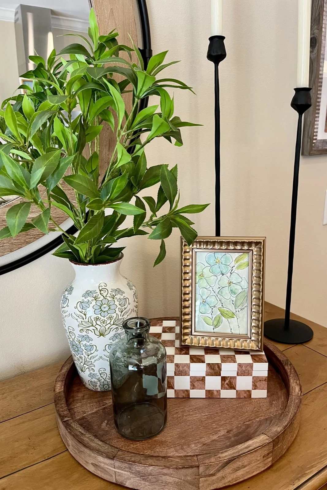 a small entryway with artwork and vase on table
