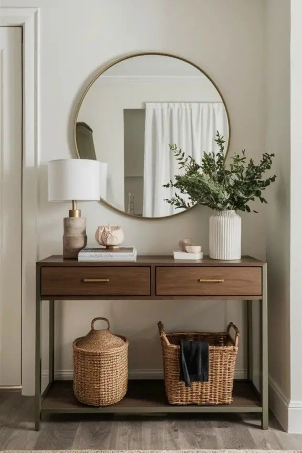a small entryway with mirror, vase and storage baskets